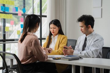 Fototapeta premium Serious Job Interview: A professional setting captures the intensity of a job interview. The candidate, nervous but determined, sits across from two interviewers.