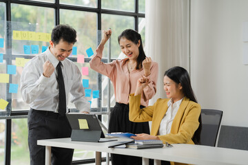 Office Celebration: A diverse team of business professionals celebrates a success, with smiles, raised fists, and a shared sense of accomplishment.