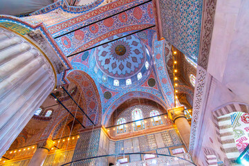 Interior view of the ornate walls and ceilings decorated with Iznik tiles and painted floral motifs...