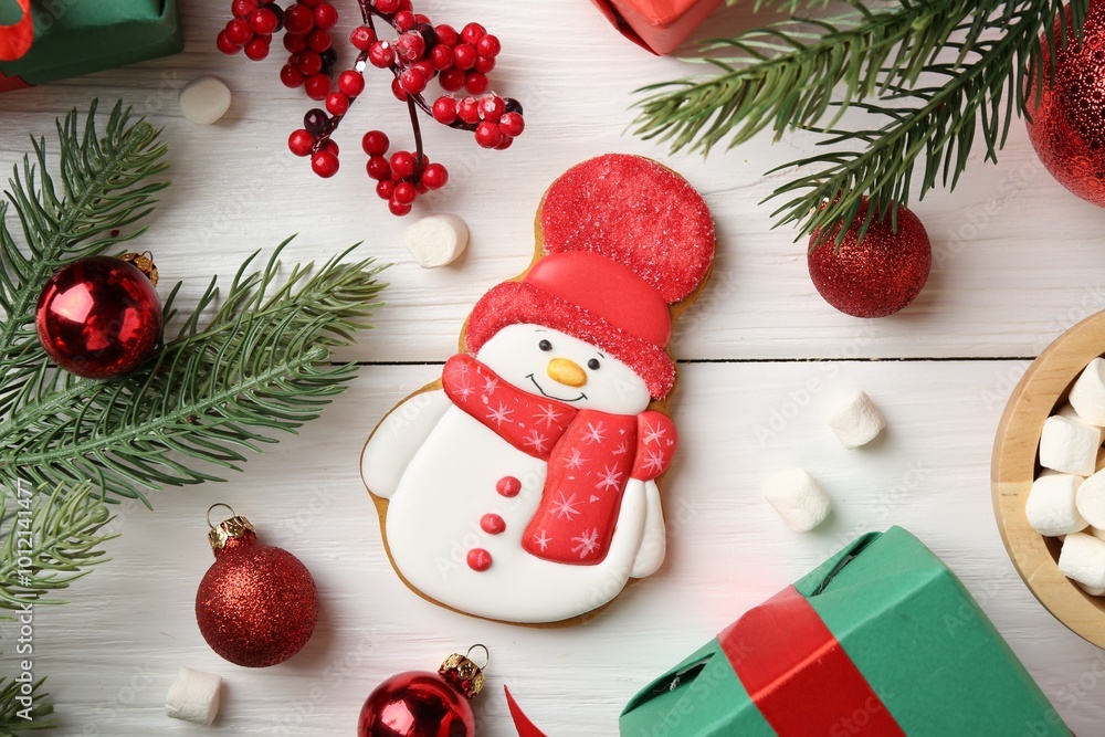 Poster Delicious cookie in shape of snowman, marshmallows and Christmas decor on white wooden table, flat lay