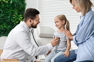 Doctor examining little girl with stethoscope and her mother in hospital