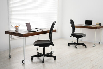 Black chair, laptop and desk in office