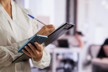 Entrepreneurial woman organizing the work and organization of her employees in her folder. Concept of boss, orders, brainstorming, organization, work calendar.