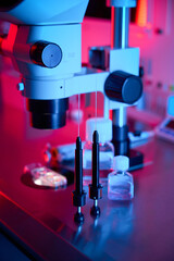 Microscope setup illuminated by red and blue lab lights