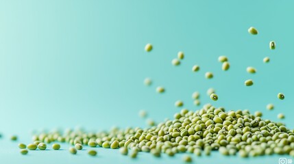 Green mung beans scattering in air against teal background