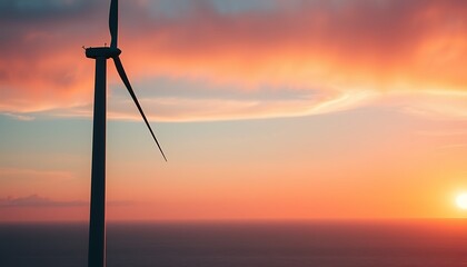 Obraz premium A towering wind turbine stands against a stunning coastal sunrise, its blades slowly rotating as the first light of day paints the sky in shades of orange, pink, and blue. 