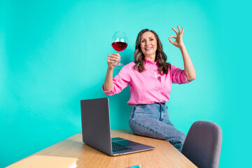 Photo portrait of lovely pensioner lady working office enjoy wine okey dressed stylish pink garment isolated on aquamarine color background