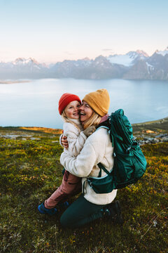 Family time - mother hugging child hiking together, travel lifestyle outdoor active vacations in mountains of Norway parent and kid daughter happy candid emotions