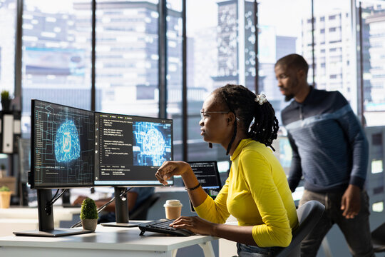 Computer scientist conducting experiments and tests to optimize machine learning models for performance and accuracy. African american IT expert in office analyzing and interpreting complex AI data