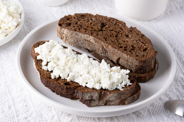 Rye bread with cottage cheese on a white table