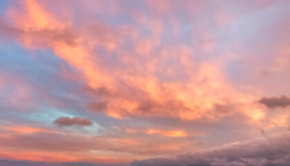 A beautiful sky tinted by the sun leaving vibrant shades of gold, pink, blue and multicolored. Clouds in the twilight evening and morning sky. Cloudy sky background in the evening, and during the day.