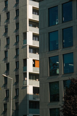 Modern apartment buildings on a sunny day with a blue sky. Facade of a modern apartment building. Glass surface with sunlight.