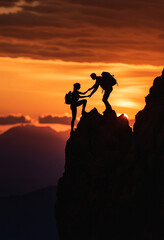 Silhouette of a man helping a woman reach a mountain peak, symbolizing help and support in the silhouette style.
