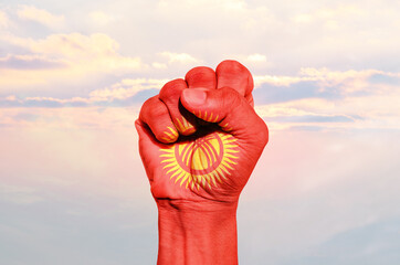 Man hand fist of Kyrgyzstan flag painted, fist flag, Strength, Power, Protest concept.
