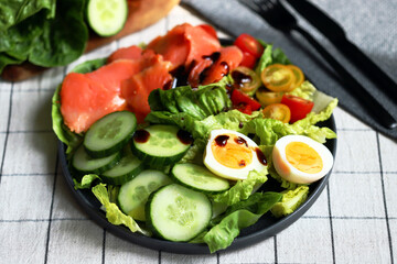 Fresh salad with cucumber, cherry tomatoes and salted salmon