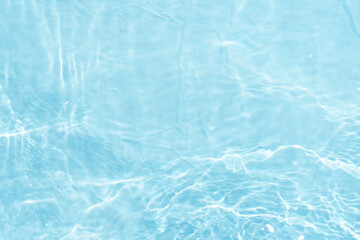 Blue water with ripples on the surface. Defocus blurred transparent blue colored clear calm water surface texture with splashes and bubbles. Water waves with shining pattern texture background.