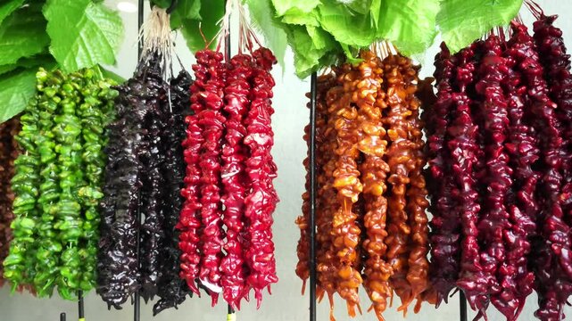 Hanging Churchkhela, a Traditional Georgian Sweet. Vibrant Colors of Nuts and Grape Juice in Motion.
