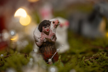 pastor cargando borrego, figura de yeso, con bokeh en el fondo