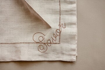 Elegant linen napkin with embroidered 'Salvage' text and hemstitch detail