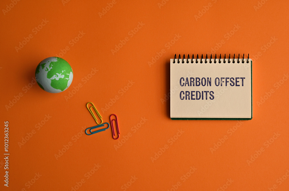 Poster there is notebook with the word carbon offset credits. it is as an eye-catching image.