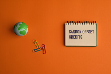 There is notebook with the word Carbon Offset Credits. It is as an eye-catching image.