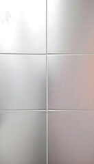 A metallic silver tile with a reflective surface, ideal for modern spaces, enhancing light and depth while adding a touch of elegance to any decor.