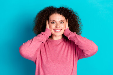 Photo of nice young woman beaming smile arms covert ears wear pink pullover isolated on teal color background