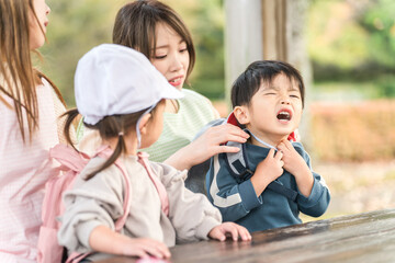 秋の公園で泣く園児と困る保育士（保育園・幼稚園・保母）
