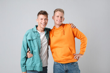 Fototapeta premium Portrait of two happy brothers on light background