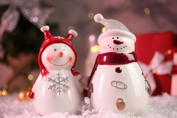 Funny snowmen figures on artificial snow, closeup