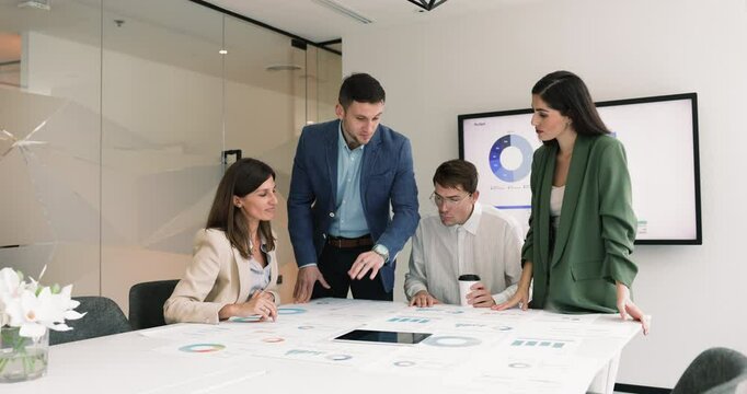 Group of financial analysts, four professionals gathered together in boardroom to develop strategy based on data analysis and trends, planning strategy, review charts and diagrams. Budget Allocation