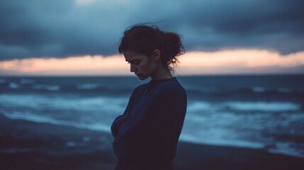 Fototapeta premium A Woman Stands by the Ocean at Dusk, Lost in Thought