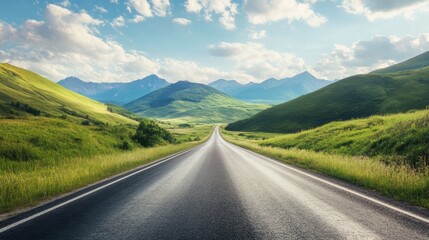 Fototapeta premium A scenic asphalt road leading towards green mountains, under a bright sky with soft, scattered clouds on a sunny day.