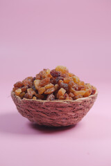 A Colorful Bowl Filled with Natural Dried Fruits Set Against a Soft Pink Background