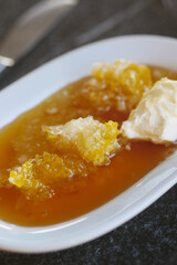 butter cream and honey in a bowl on table .