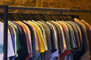 A stylish boutique showcases an array of vibrant hanging Tshirts in a wellorganized display