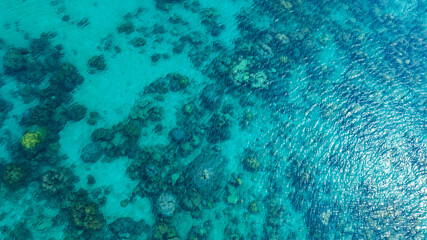 Top view, sandy beach background for summer vacation concept. Nature of beach and summer sea water with sunlight, sparkling sea water, coral reefs, underwater.