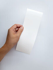 Hand hold white empty shopping receipt mockup on gray background. Template for design. Places for...