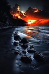 Fototapeta premium Dramatic sunset over a rocky beach with dark clouds reflecting in wet sand and vibrant orange sky.