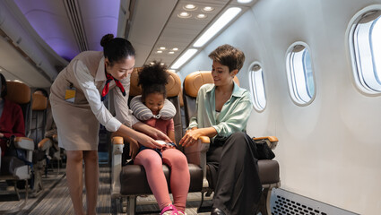 Friendly flight attendant take car kid passenger on board. Cabin crew helping curly African girl to...