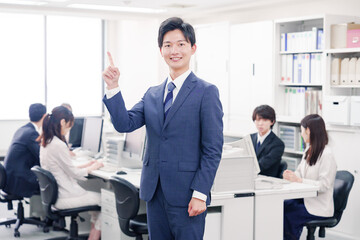 オフィスでポイントを指差すスーツを着たビジネスマン