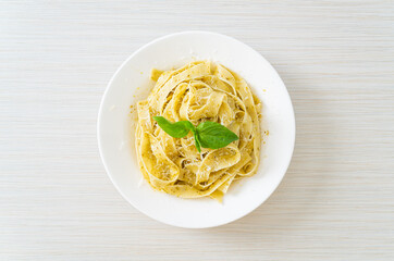 pesto fettuccine pasta with parmesan cheese on top