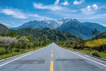 Mountain landscape next to asphalt highway under blue sky