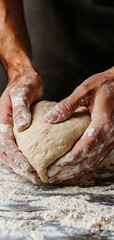 Hands kneading dough on a flour-covered surface