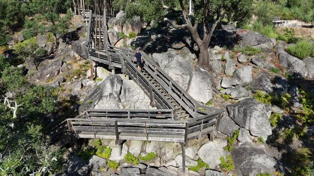 Close rone footage of wooden stairs with a man going up in the Passadi&ccedil;os do Paiva hike in Portugal.