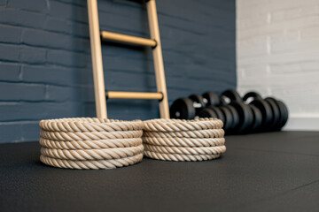 Close-up of gym rope with knots, fitness gym background, focus on equipment.