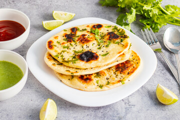 Naan is a soft, fluffy, and slightly chewy Indian flatbread, traditionally baked in a tandoor, often served with curries.