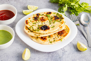 Naan is a soft, fluffy, and slightly chewy Indian flatbread, traditionally baked in a tandoor, often served with curries.