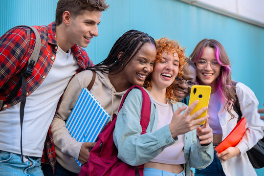 Five students having fun with mobile phones creating content on social media.