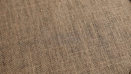 Grey burlap fabric reveals coarse weave with visible gaps between fibers. Rough texture highlights...